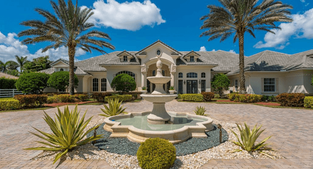 photograph of large home with fountain in the middle